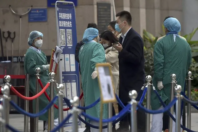 Medical workers attend to masked residents who came for a coronavirus test at a hospital in Chengdu in southwest China's Sichuan province, Tuesday, December 08, 2020. Authorities ordered mass coronavirus testing and locked down some locations in the southwestern Chinese city of Chengdu following the detection of several new virus cases. (Photo by Chinatopix via AP Photo)