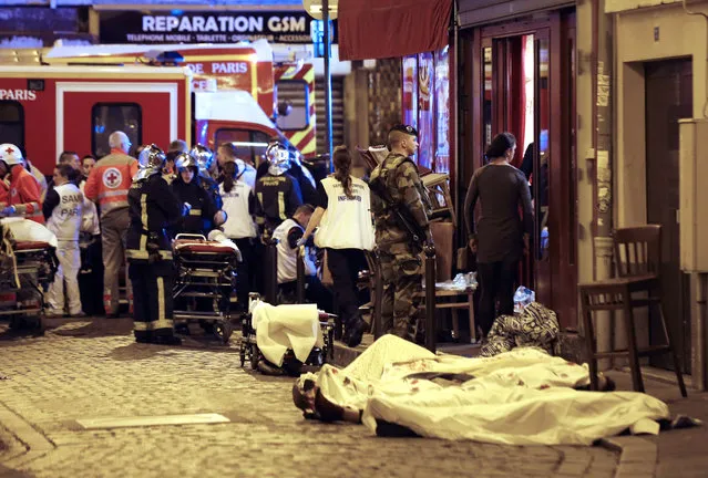 A soldier stands by victims in the10th district of Paris, Friday, November 13, 2015. (Photo by Jacques Brinon/AP Photo)