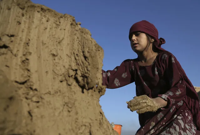 In this Wednesday, June 19, 2019, photo, Hameda, 8, works at a brick factory on the outskirts of Kabul, Afghanistan. The U.S. and its allies have sunk billions of dollars of aid into Afghanistan since the invasion to oust the Taliban 18 years ago, but the country remains mired in poverty. Signs of hardship are everywhere, from children begging in the streets to entire families – including children as young as five or six – working at brick kilns in the sweltering heat. (Photo by Rahmat Gul/AP Photo)
