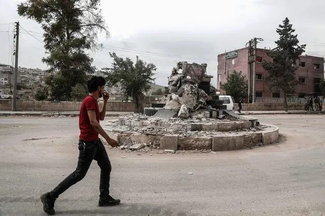 A general view taken on April 26, 2018, shows a man walking past the statue of “Kawa”, the blacksmith who was a central figure in a Kurdish legend about the new year celebration of Noruz, after Ankara- backed forces destroyed it after they captured the northern Syrian enclave of Afrin from Kurdish fighters in recent months. Tens of thousands of people were displaced by the Turkish- led assault on the Afrin region, whose small towns and villages were home to mostly Syrian Kurds. (Photo by Sameer Al-Doumy/AFP Photo)