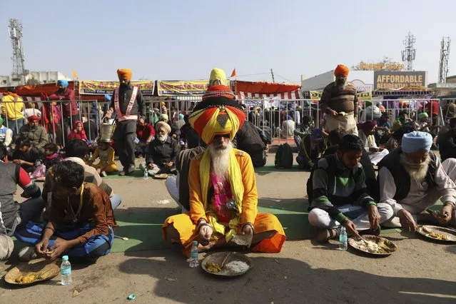 Farmers eat their lunch at the Delhi- Haryana border, outskirts of New Delhi, Monday, December 14, 2020. Tens of thousands of protesting Indian farmers have called for a national strike on Monday, the second in a week, to press for the quashing of three new laws on agricultural reform that they say will drive down crop prices and devastate their earnings. (Photo by Manish Swarup/AP Photo)