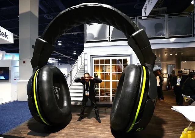 Show attendee Nezar Khajah poses with a giant pair of headphones at the International Consumer Electronics show (CES) in Las Vegas, Nevada January 6, 2015. (Photo by Rick Wilking/Reuters)