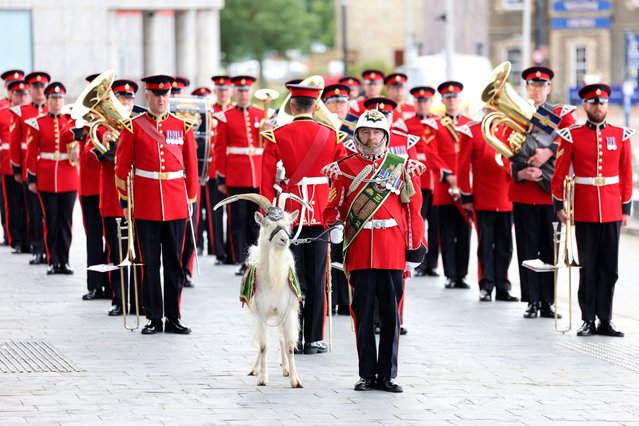 The Royal Welsh form a guard of honour alongside the mascot goat Billy ahead of the arrival Britain's King Charles III and Britain's Queen Camilla to meet members of the Welsh Parliament during a visit to commemorate the 25th anniversary of the Senedd, in Cardiff on July 11, 2024. (Photo by Chris Jackson/Pool via AFP Photo)