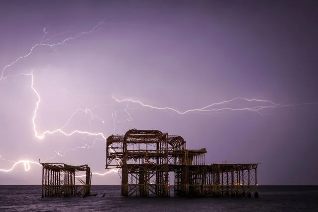 Lightning lights up the sky behind Brighton’s ruined West Pier, England. (Photo by Adam Gerrard/The Guardian)