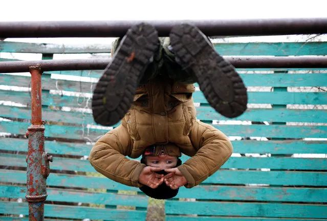 A boy does physical exercises during military training undergone by students of the General Yermolov Cadet School and members of a Cossack community at a boot camp of the Russkiye Vityazi (Russian Knights) military patriotic club in the village of Sengileyevskoye in Stavropol region, Russia, November 2, 2016. (Photo by Eduard Korniyenko/Reuters)