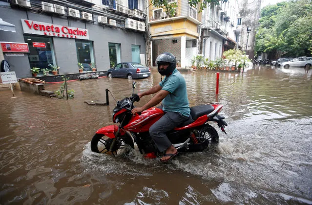 A man rides a motorcycle through a water-logged street after heavy rains in Mumbai, June 7, 2018. (Photo by Francis Mascarenhas/Reuters)