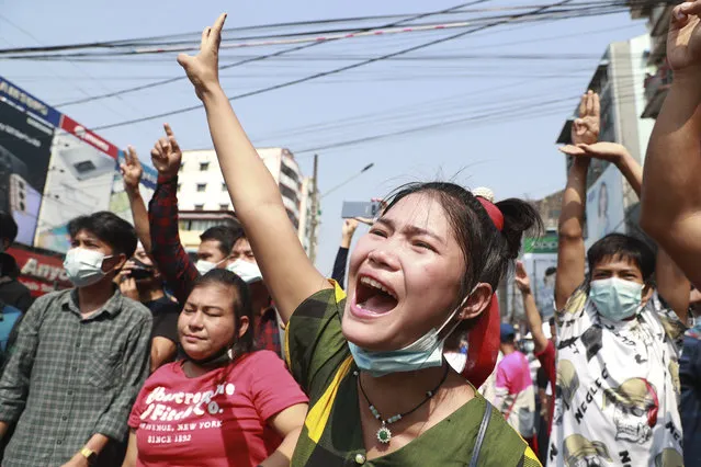 A protester shouts as she flashes the three-fingered salute during a protest rally in Yangon, Myanmar, on February 6, 2021. (Photo by AP Photo/Stringer)