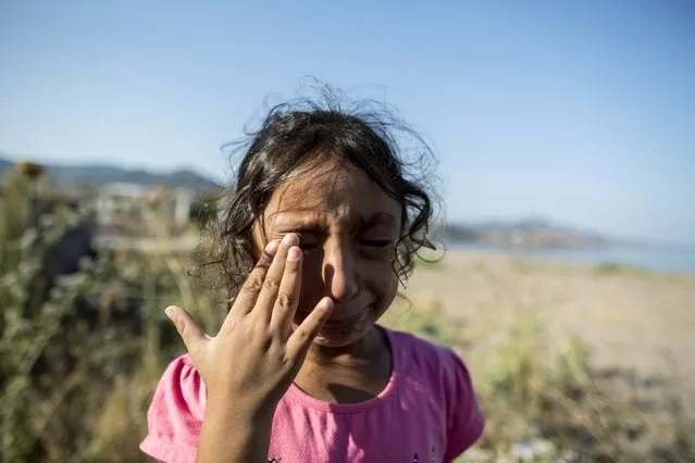 Yasmine, a 6-year-old migrant from Deir Al Zour in war-torn Syria, cries at the beach after arriving on the Greek island of Lesbos September 11, 2015. Yasmine said that the men who brought her family across the narrow sea between Bodrum in Turkey and this Greek tourist island threw away the dress her grandmother gave her. (Photo by Zohra Bensemra/Reuters)