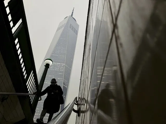 A commuter steps into the subway as smoke from wildfires in Canada partially obscure One World Trade Center in lower Manhattan, Tuesday, June 6, 2023, in New York. (Photo by Daniel P. Derella/AP Photo)