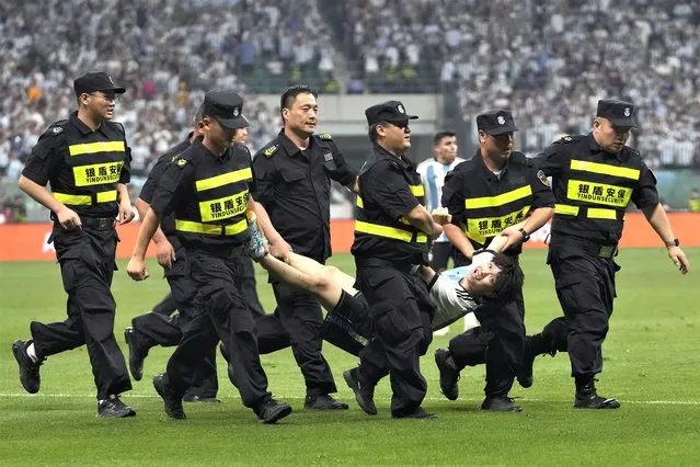 Security guards remove a pitch invader during the friendly soccer match between Argentina and Australia at Workers' Stadium in Beijing, China, Thursday, June 15, 2023. (Photo by Andy Wong/AP Photo)