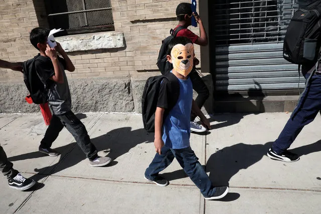 Children, with their faces covered with masks, leave the Cayuga Center, which provides foster care and other services to immigrant children separated from their families, in New York City, U.S., June 21, 2018. (Photo by Mike Segar/Reuters)