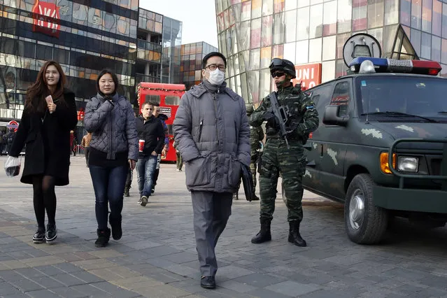 Heavily armed Chinese paramilitary police guard a popular mall in the Sanlitun district of Beijing, China, Thursday, December 24, 2015. Increased security could be seen at the area as the U.S. and British embassies in the Chinese capital issued travel advice on possible threats against westerners in the Sanlitun area. (Photo by Ng Han Guan/AP Photo)
