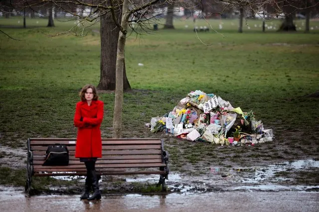 A well-wisher reflects near floral tributes in honour of Sarah Everard, the missing woman whose remains were found in woodland in Kent, at the bandstand on Clapham Common in south London on March 17, 2021. Prime Minister Boris Johnson said Wednesday Britain needed “a change in our culture” to tackle violence against women and girls, as he came under pressure over the government's response to the issue which has been thrust into the national spotlight following the disappearance this month of 33-year-old Sarah Everard, whose remains were found in woodland last week. A serving London police officer has been charged with her kidnap and murder. (Photo by Tolga Akmen/AFP Photo)