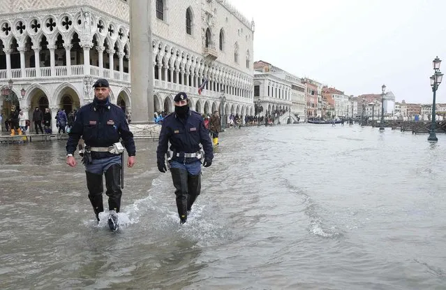 Policemen patrol a flooded St. Mark's Square during a period of seasonal high water in Venice, February 6, 2015. (Photo by Manuel Silvestri/Reuters)