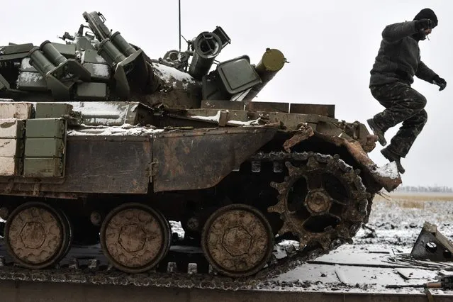 A Ukrainian serviceman jumps off a tank damaged during fighting with pro-Russian separatist forces, as it stays on a towing truck outside Debaltseve, eastern Ukraine February 10, 2015. (Photo by Alexei Chernyshev/Reuters)