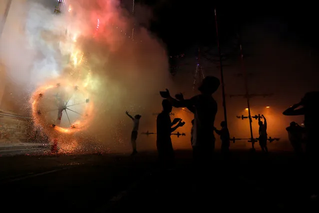 Enthusiasts celebrate during a mechanised ground fireworks display during week-long celebrations marking the feast of the Assumption of Our Lady in Mosta, Malta on August 15, 2018. (Photo by Darrin Zammit Lupi/Reuters)