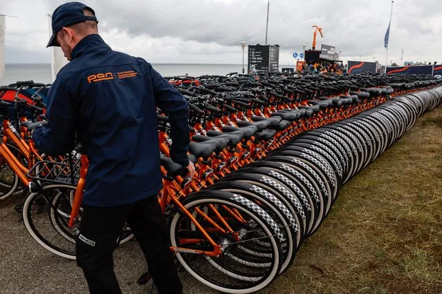 A Dutch Grand Prix employee arranges bicycles for fans at the entrance of the Dutch Formula One Grand Prix at The Circuit Zandvoort, in Zandvoort on August 27, 2023. (Photo by Simon Wohlfahrt/AFP Photo)