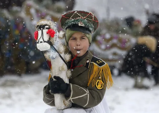 A boy, dressed in a costume, takes part in a performance while visiting local houses during the celebrations for Malanka holiday in the village of Krasnoilsk in Chernivtsi region, Ukraine, January 14, 2016. (Photo by Valentyn Ogirenko/Reuters)
