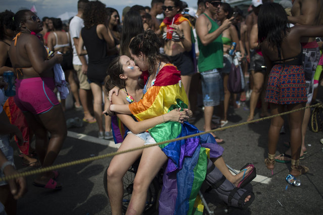 Two women kiss during the Gay Pride Parade at Copacabana beach in Rio de Janeiro, Brazil, Sunday, December 11, 2016. People took part in Rio de Janeiro's 21st Gay Pride Parade to fight for more justice and inclusive society which recognizes equal rights for the gay community. (Photo by Leo Correa/AP Photo)