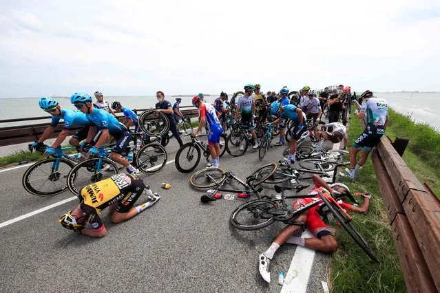 Riders react after a massive pack crash during the 15th stage of the Giro d'Italia 2021 cycling race, a 147km race between Grado and Gorizia on May 23, 2021. (Photo by Luca Bettini/AFP Photo)