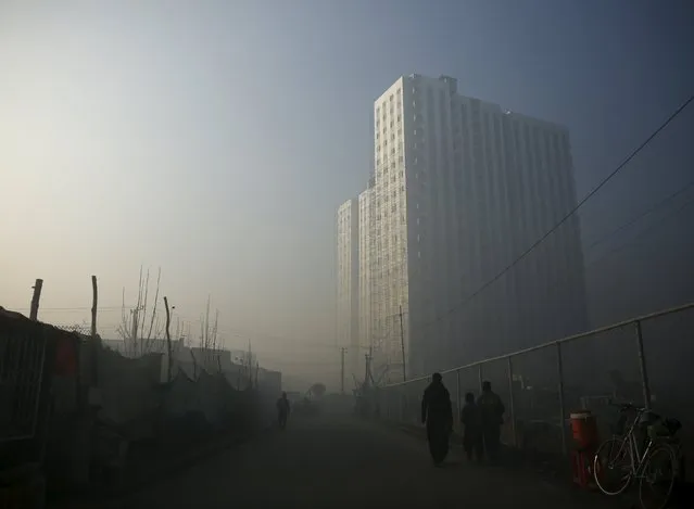 People head to work next to a newly build residential building, during a foggy morning in Kabul, Afghanistan January 5, 2016. (Photo by Ahmad Masood/Reuters)