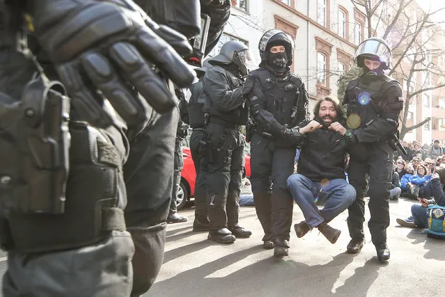 Riot police carry away an activist during a demonstration organized by the Blockupy movement to protest against the policies of the European Central Bank (ECB) after the ECB officially inaugurated its new headquarters earlier in the day on March 18, 2015 in Frankfurt, Germany. (Photo by Simon Hofmann/Getty Images)