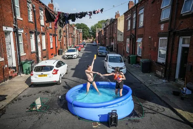 Residents take a dip in a paddling pool to cool off outside their home on July 19, 2022 in Leeds, United Kingdom. Temperatures exceeded 40C in parts of England today after the Met Office issued its first red extreme heat warning. Record-breaking temperatures were reached across the UK. (Photo by Christopher Furlong/Getty Images)