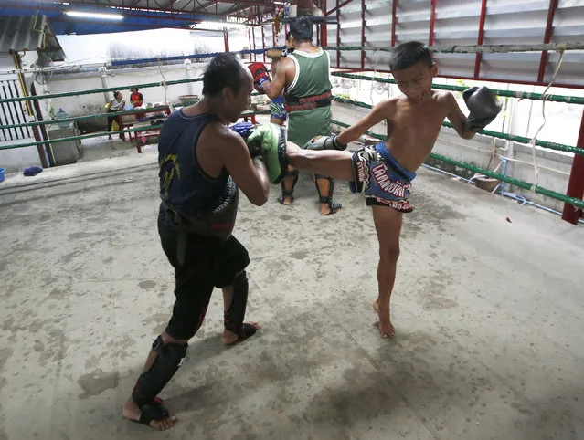 In this Wednesday, November 14, 2018, photo, Thai kickboxer Chaichana Saengngern, 10-years old, practices kicks at a training camp in Bangkok, Thailand. Thai lawmakers recently suggested barring children younger than 12 from competitive boxing, but boxing enthusiasts strongly oppose the change. They say the sport is part of Thai culture and gives poor families the opportunity to raise a champion that will lift their economic circumstances. (Photo by Sakchai Lalit/AP Photo)