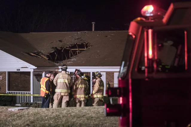 Firefighters with the Winston-Salem Fire Department respond after a car crashed into a home Friday, December 30, 2016 in Winston-Salem, N.C. Authorities say a woman driving at least 70 mph hit a hill and launched into the roof of a group home in North Carolina. Police believe the woman may have suffered a medical emergency while driving. Remarkably, no one inside the home was injured. (Photo by Andrew Dye/The Winston-Salem Journal via AP Photo)