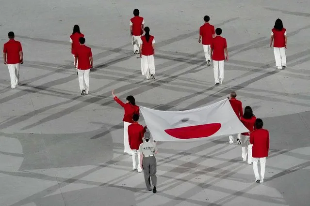 The Japanese flag is walked into view during the Opening Ceremony for the Tokyo 2020 Olympic Games at Tokyo Olympic Stadium on Friday, July 23. 2021. (Photo by Toni L. Sandys/The Washington Post)