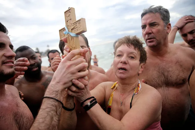 Orthodox faithful hold a wooden crucifix during Epiphany day celebrations in the southern suburb of Faliro in Athens, Greece January 6, 2017. (Photo by Alkis Konstantinidis/Reuters)