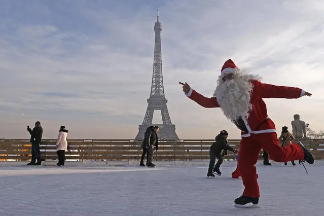 A man dressed as Santa Claus skates on an ice rink across from the Eiffel Tower as part of the holiday season, in Paris, on December 12, 2013. (Photo by Jacky Naegelen/Reuters)
