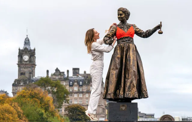 Caroline Kennedy Alexander, breast cancer survivor and founder of LoveRose, an Edinburgh-based luxury lingerie brand offering bras designed specifically for women who have had surgery following breast cancer, fits living statue Izabela Walkowiak-Radcliffe as Marie Curie with one of it's post-surgery bras to remind women to check their breasts for early signs of breast cancer at the Scottish National Gallery in Edinburgh on Friday, October 21, 2022. (Photo by Jane Barlow/PA Images via Getty Images)