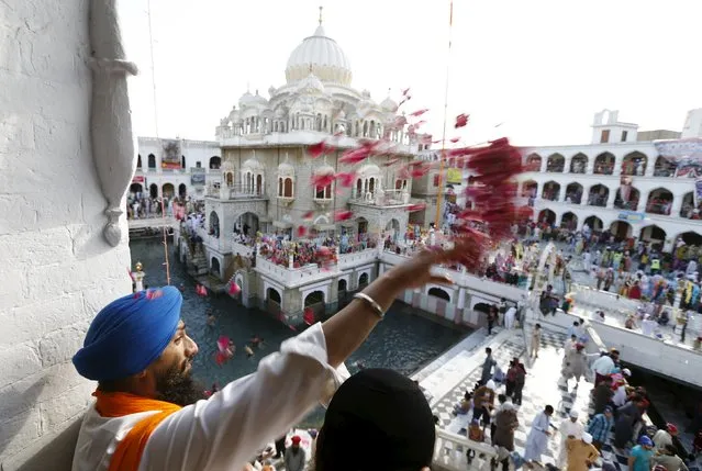 A Sikh devotee throws flower petals as the procession passes by during the Baisakhi festival at Panja Sahib shrine in Hassan Abdel April 13, 2015. (Photo by Caren Firouz/Reuters)