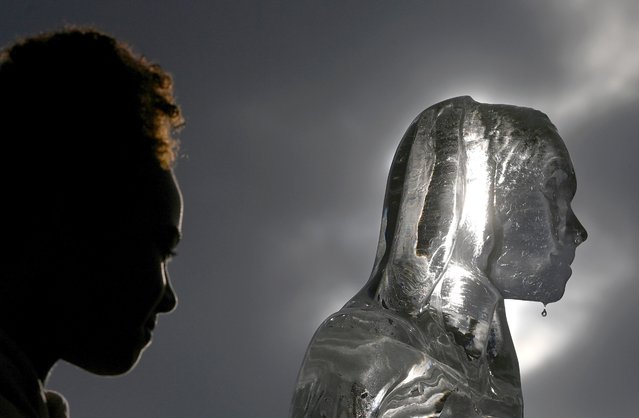 Water falls off an ice sculpture depicting a woman walking to collect water, as environmental and public health campaign group WaterAid highlights the threat posed globally by climate change to healthy water supplies, in London, Britain, September 15, 2021. (Photo by Toby Melville/Reuters)