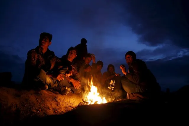 Migrants who are waiting to cross the Greek-Macedonian border, sit by the fire near the village of Idomeni, Greece, March 3, 2016. (Photo by Marko Djurica/Reuters)