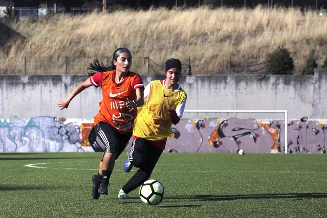 Farkhunda Muhtaj, left, the captain of the Afghanistan women's national team, runs with the ball during a training session with her teammates at a soccer pitch in Odivelas, outside Lisbon, Thursday, September 30, 2021. Muhtaj, who lives in Canada, flew to Lisbon to meet the other girls and direct the training session with them. The girls and their families arrived in Portugal Sept.19 after an international coalition came to their rescue. (Photo by Ana Brigida/AP Photo)