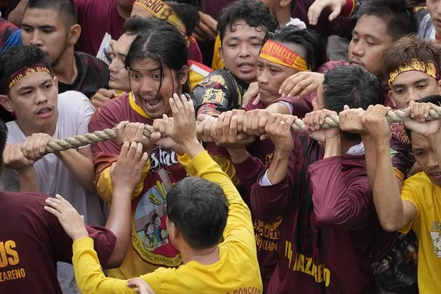 Devotees grab the rope as they pull the glass-covered cart carrying Black Nazarene during its annual procession which was resumed after a three-year suspension due to the coronavirus pandemic on Tuesday, January 9, 2024 in Manila, Philippines. (Photo by Aaron Favila/AP Photo)