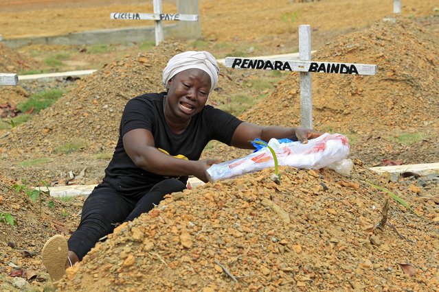 Ebola survivor Sianneh Beyan mourns as she lays flowers at the grave of her sister who died of the ebola virus at Disco Hill Safe Burial Site, in Margibi County, Liberia, 09 March 2016. Decoration Day or Memorial Day is observed on the second Wednesday of March in Liberia, 09 March 2016 for the current year, to honor and remember the dead. (Photo by Ahmed Jallanzo/EPA)