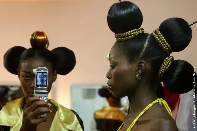 Nigerian fashion models Mary Jane Unueroh and Fome Emede (L) take a photo themselves with a cell phone behind the curtain  during their fashion show  to promote ethnic fashion June 13 in Tel Aviv, Israel