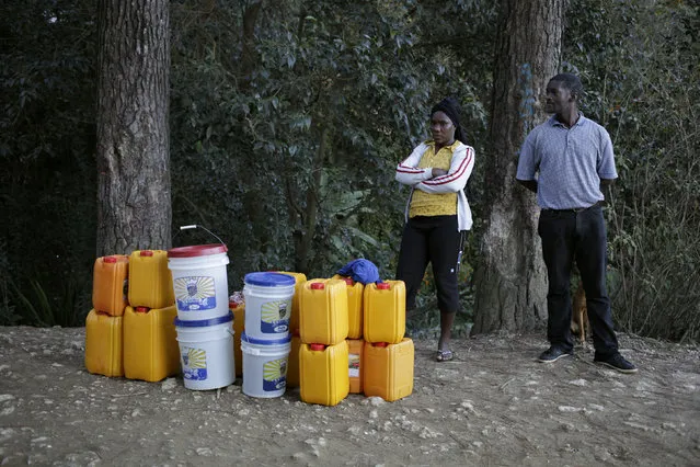 Andre Louis Jean (R) and Jemen David wait for a tap-tap to transport about 200L of water in cotainers in the outskirts of Kenscoff, Haiti, February 23, 2016. March 22 marks World Water Day. (Photo by Andres Martinez Casares/Reuters)