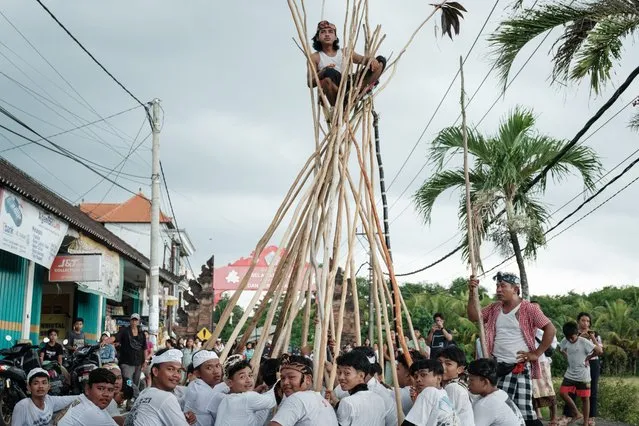 Balinese people take part in the Mekotek ritual during which young villagers perform a symbolic victory over evil with wooden sticks as a part of the Kuningan celebration, held every 210 days of the Balinese calendar, in Badung, Bali, on March 9, 2024. Balinese Hindu followers are celebrating the prosperity day of Kuningan, a time for commemoration as the ancestors return to heaven after ten days dwelling on earth. (Photo by Yasuyoshi Chiba/AFP Photo)