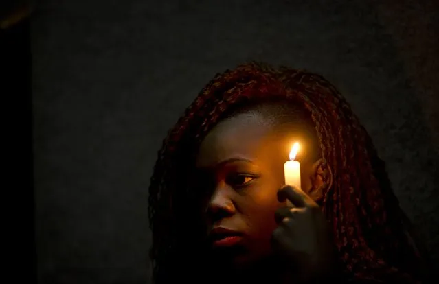 Christine Ochieng holds a candle in memory of those who died in the Garissa University attack, at a memorial service attended by students, relatives and others marking the first anniversary, in Nairobi, Kenya Saturday, April 2, 2016. Kenyans on Saturday marked the first anniversary of the attack, when four extremist gunmen massacred 148 people, with renewed criticism of the government's handling of the crisis. (Photo by Ben Curtis/AP Photo)