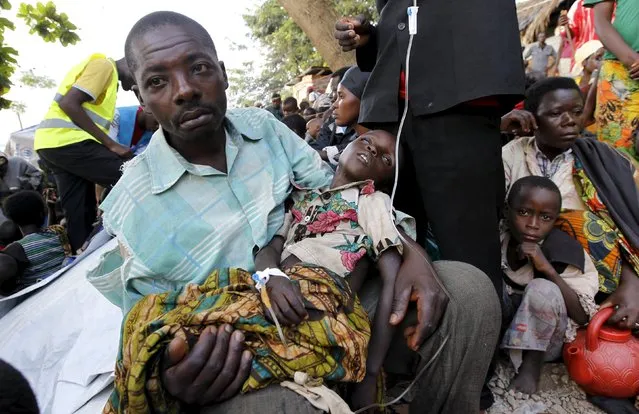 A Burundian refugee carries his sick child as he receives treatment at a makeshift clinic on the shores of Lake Tanganyika in Kagunga village in Kigoma region in western Tanzania, as they wait for MV Liemba to transport them to Kigoma township, May 17, 2015. (Photo by Thomas Mukoya/Reuters)