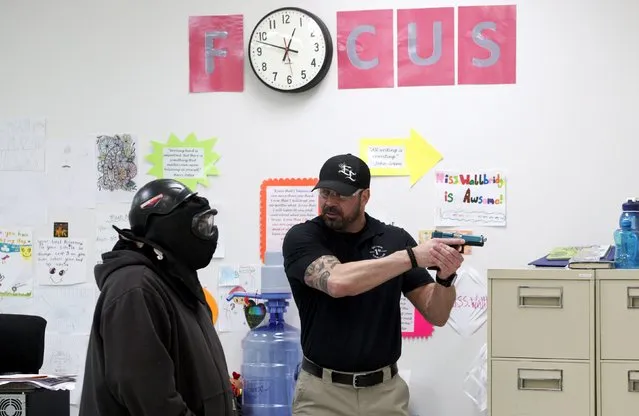 Tony Schluck (R), an instructor for TAC ONE Consulting, demonstrates a defensive technique in a middle school classroom during an Active Shooter Response course in Denver April 2, 2016. (Photo by Rick Wilking/Reuters)