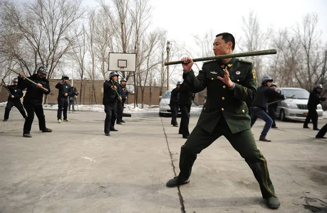 A paramilitary policeman demonstrates for officers during a security drill in Urumqi, Xinjiang autonomous region, March 18, 2014. Around 40 ethnic Han, Uighur and Kazak local officers attended the drill on Wednesday. (Photo by Reuters/Stringer)