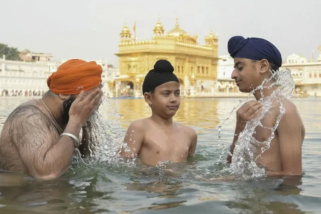 Sikh devotees bath in the holy sarovar (water tank) on the occasion of “Baisakhi”, a spring harvest festival, in Amritsar on April 13, 2024. (Photo by Narinder Nanu/AFP Photo)
