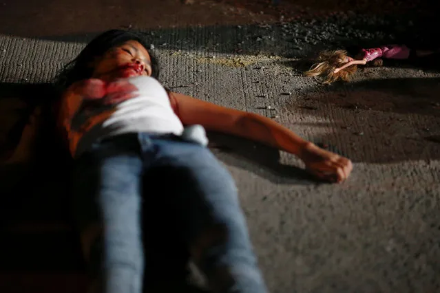 A 17 year old girl lays dead next to her doll after she and her friend were killed by unknown motorcycle-riding gunmen, in an alley in Manila, Philippines early October 26, 2016. According to the police, a sign on a cardboard reading “Tulak ka, hayop ka”, which translates to “You are a (drug) pusher, you are an animal” was found with the body of girl's friend. (Photo by Damir Sagolj/Reuters)