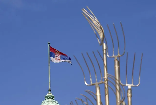 A Serbian flag waves on the Serbian Parliament building during a protest in front of the Serbian Parliament building in Belgrade, Serbia, Saturday, April 10, 2021. Environmental activists are protesting against worsening environmental situation in Serbia. (Photo by Darko Vojinovic/AP Photo)