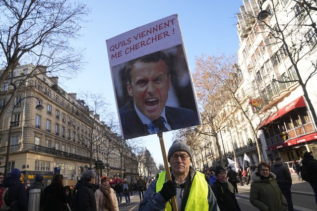 A protester holds a portrait of French President Emmanuel Macron reading “Let them come get me” during a demonstration against plans to push back France's retirement age, Tuesday, February 7, 2023 in Paris. The demonstration comes a day after French lawmakers began debating a pension bill that would raise the minimum retirement from 62 to 64. The bill is the flagship legislation of President Emmanuel Macron's second term. (Photo by Michel Euler/AP Photo)